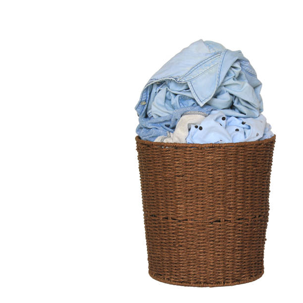 istock Clothes in a laundry wooden basket on white background 673305080