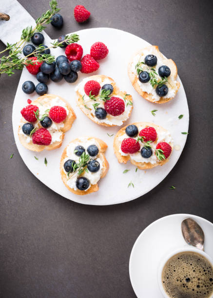 istock Cup of coffee with fruit sandwiches 673312358