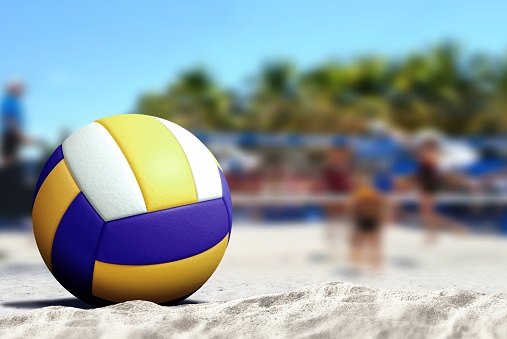 This is a close up photo of a white leather volleyball isolated on a white background sitting in the sand