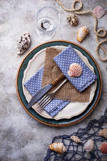 istock Marine style table setting with sea shells, fishnet and rope 673322560