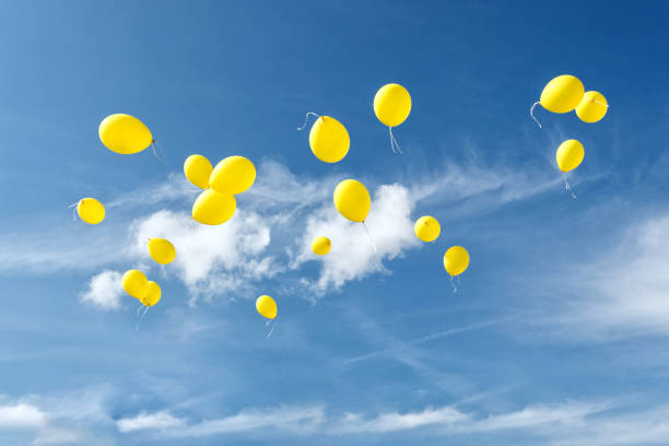 istock Celebration traditions. Yellow balloons in blue sky. 673323240