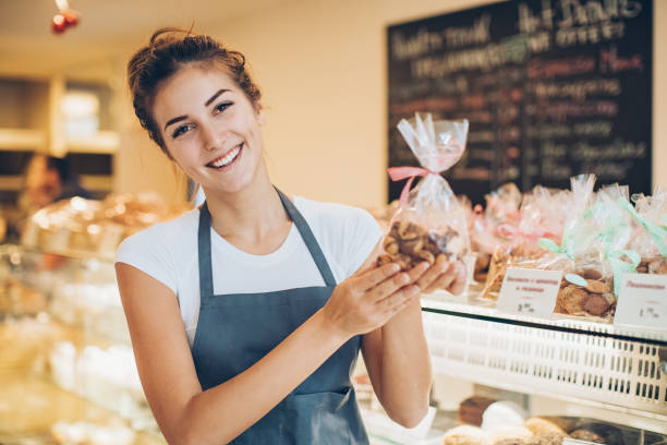 istock Beautiful baker holding a cookies package 673323662