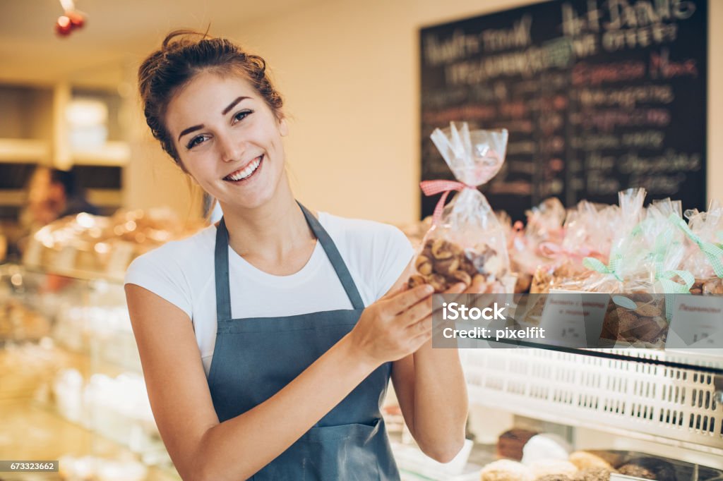 Beautiful baker holding a cookies package Bakery owner holding package of cookies Christmas Stock Photo