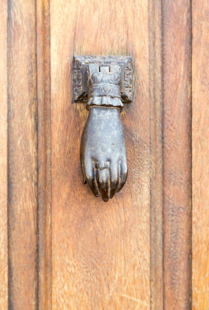 Old rustic vintage style door knocker in woman hand shape with ring