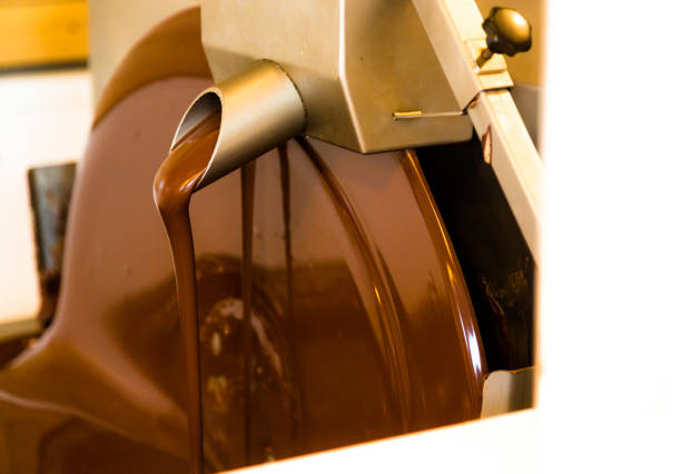 Liquid chocolate mixer in chocolate factory. Horizontal close up crop