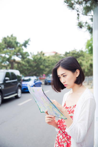 istock young beautiful woman reading map on the road 673329622