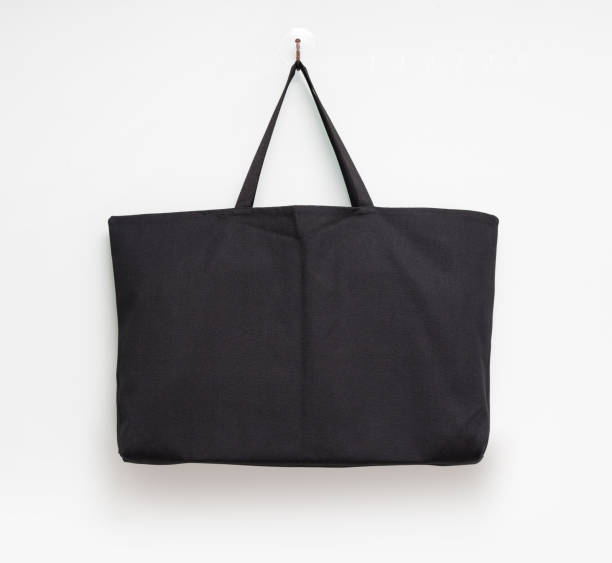 istock Hanging fabric bag on white wall background. Shopping pouch textile. 673330114