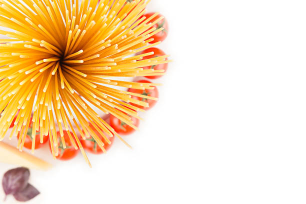 istock Ingredients Italian pasta top view -  sheaf  spaghetti, cherry tomatoes, basil, cheese on white wood board with empty copy space as decorative border background. 673336218