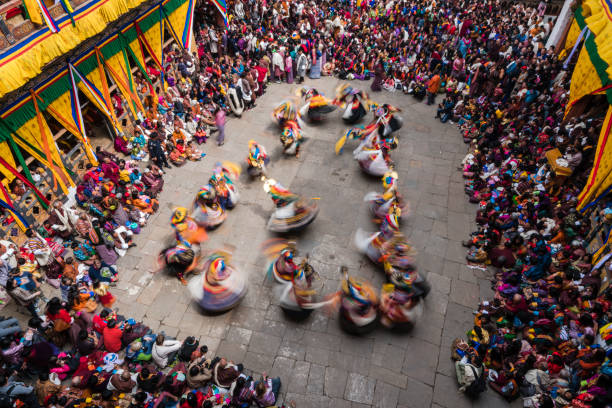 группа танцоров чама или танцоров в масках, выполняющих очищение пространства и призывах к благословению божеств на фестивале буддизма paro  - taktsang monastery фотографии стоковые фото и изображения