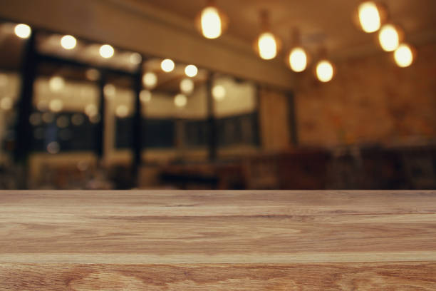 istock wooden table in front of abstract restaurant lights background 673337348