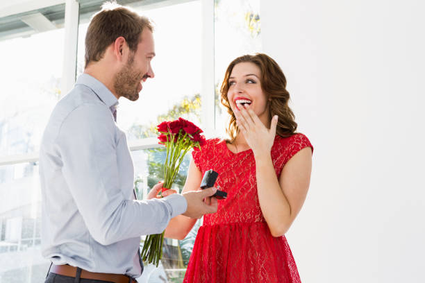 istock Man offering flowers and engagement ring 673337686