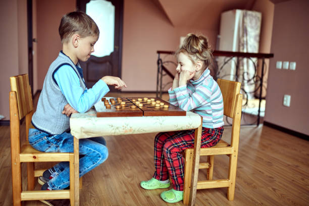 istock Children playing draughts or checkers board game 673349806
