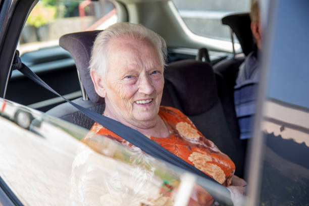 Portrait of serious old elderly woman aged 80s dressed in hat outdoors in the background of road. Slow Motion