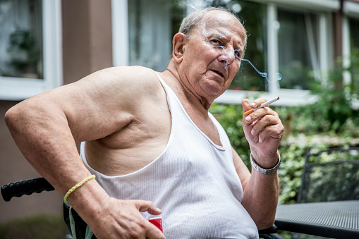 Hombre mayor sobrepeso fumar cigarrillo photo