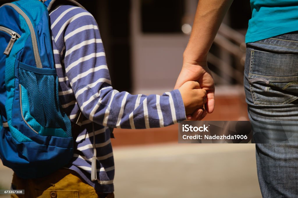 going to school- mother holding hand of son going to school- mother holding hand of son on street Mother Stock Photo