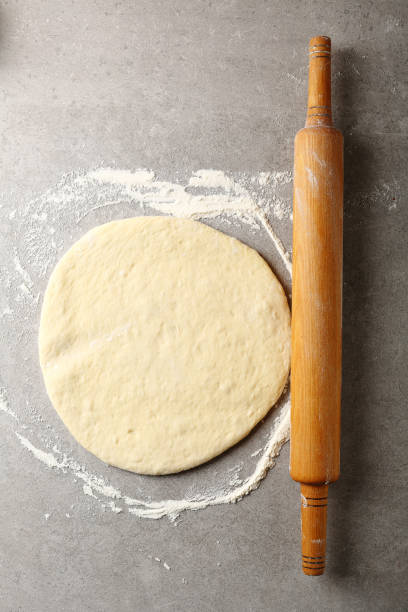 istock Raw dough on concrete and rolling pin, food top view 673357840