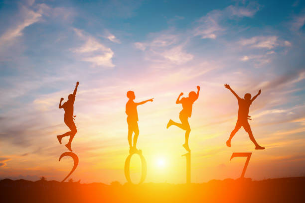 istock Silhouette of young man jumping on numbers 2017 with sunset 673358932