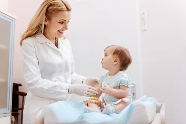 istock Attractive nurse standing near baby 673361158