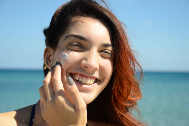 istock beautiful girl apply sunscreen  on the beach 673367260