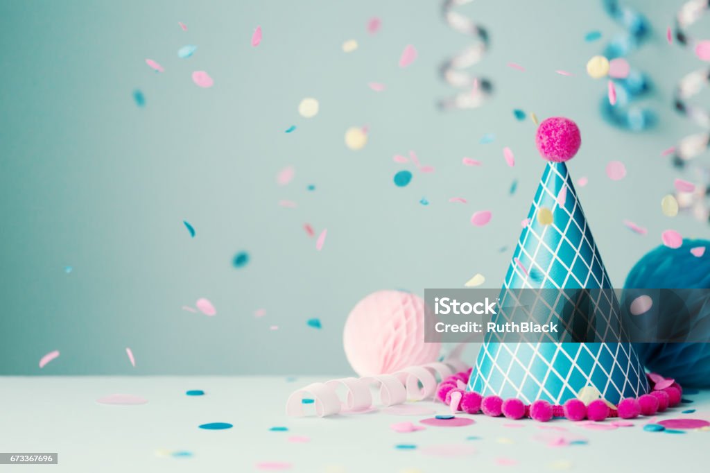 Party hat and falling confetti Colorful party hat with streamers and confetti Party Hat Stock Photo