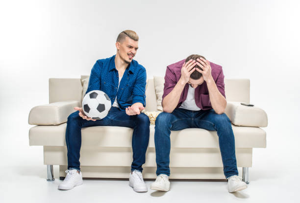 istock Friends sitting on couch with soccer ball 673371454