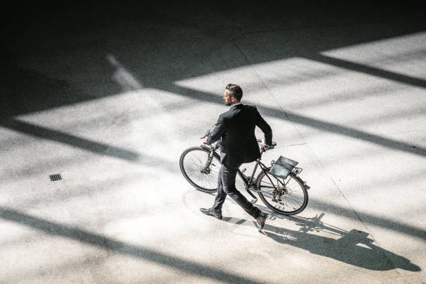 overhead view on elegant businessman going with bycicle in city