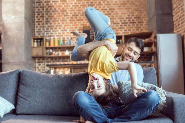 istock Happy father and son having fun together on sofa 673374946