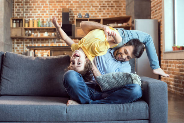 istock Happy father and son having fun together on sofa 673375136