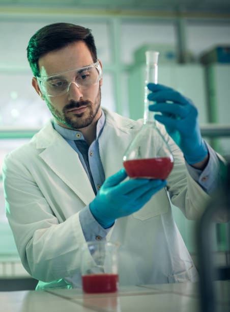 istock Male microbiologist using beaker and analyzing chemical substances in a laboratory. 673375154