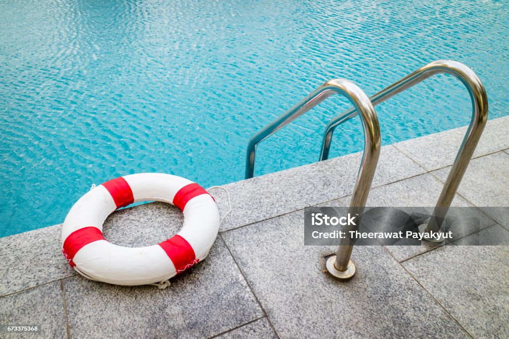 Life ring at swimming pool.emergency tire floating at swimming pool. Swimming Pool Stock Photo