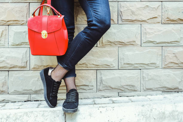 Long hair brunette woman outdoor Women's feet near wall with red backpack in hands legs against the wall stock pictures, royalty-free photos & images