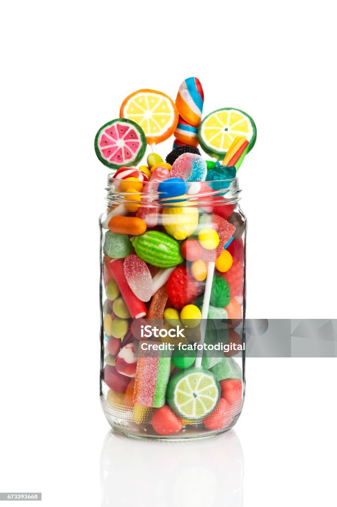 Candy jar on white background Front view of an open candy jar filled with multi colored candies and jelly beans standing on white background. Some candies are spilled out of the jar directly on the background. DSRL studio photo taken with Canon EOS 5D Mk II and Canon EF 100mm f/2.8L Macro IS USM Candy Jar Stock Photo