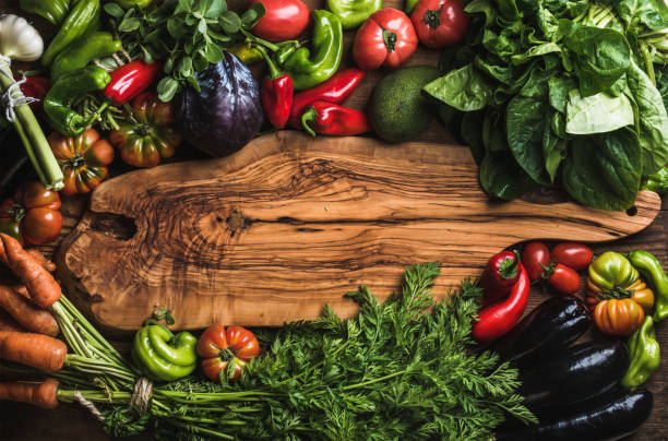 istock Fresh raw vegetable ingredients for healthy cooking or salad making with rustic olive wood board in center 673399560