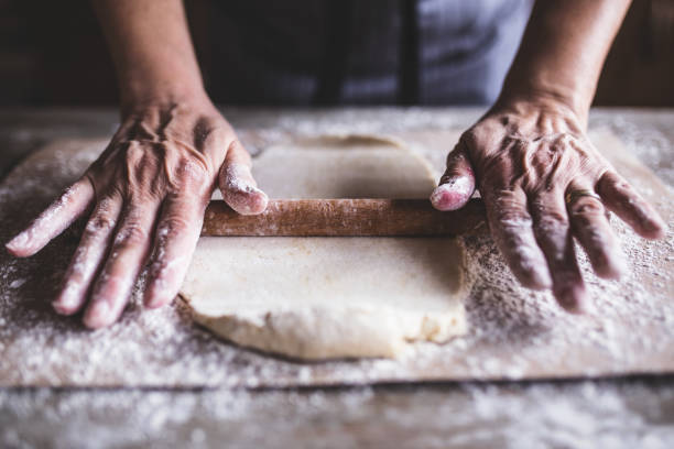 hands baking dough with rolling pin on wooden table - chef baker bakery flour imagens e fotografias de stock