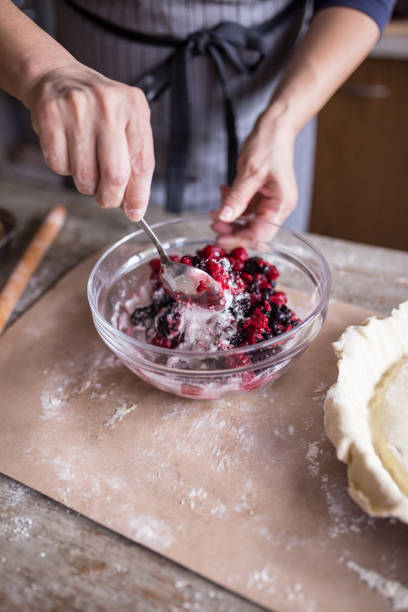 istock Woman mixing berries with sugar for pie 673404630