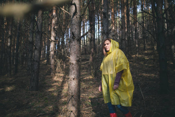 istock Autumn female in raincoat in forest 673404640