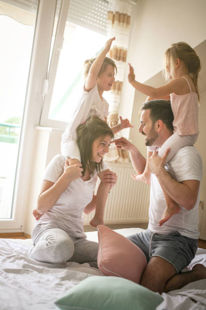 istock Happy family having fun on bed. 673405428