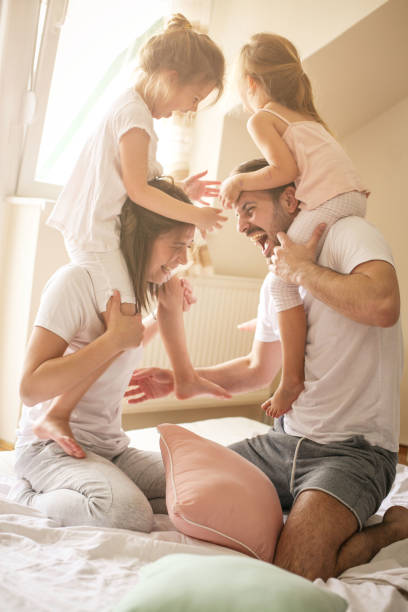 istock Happy family having fun on bed. 673405584