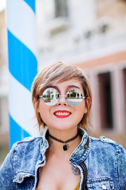 Portrait of smiling thai girl Portrait of smiling thai girl wearing sunglasses and jeans jacket sonnenbrille stock pictures, royalty-free photos & images