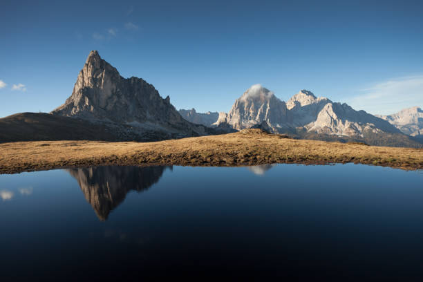 istock Ra Gusela mount reflects itself over a little alpine lake in Dolomites at evening 673421054
