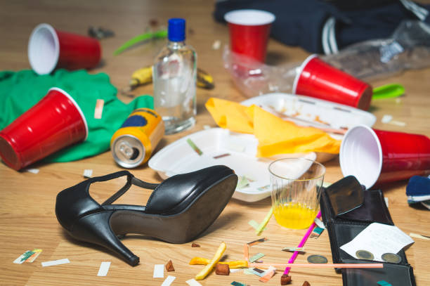 Terrible mess after party. Trash, bottles, food, cups and clothes on the floor. Messy apartment after guests leaving or the next morning. Horrible chaos after crazy wild night. Hangover concept. after party stock pictures, royalty-free photos & images