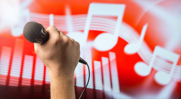 Man holding microphone in front of an abstract music and note background. Karaoke or singing contest theme. Vocal coaching or live singing concept with copy space for text.