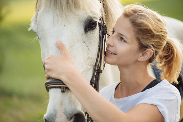 istock Woman with white horse 673442354