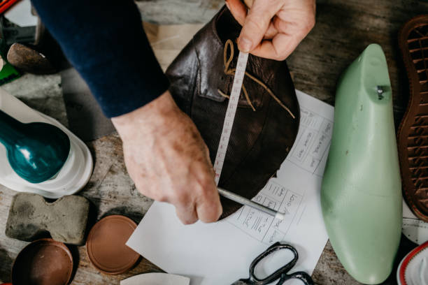 istock Close up of a shoemaker taking measurements for making a shoe 673442712