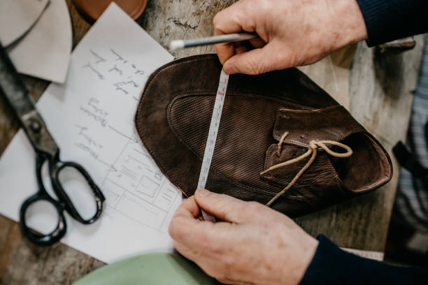 istock Close up of cobbler taking measurements for making a shoe 673443174
