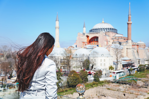 Portrait of beautiful woman on terrace with view of Hagia Sophia, Sultanahmet District, Istanbul, Turkey