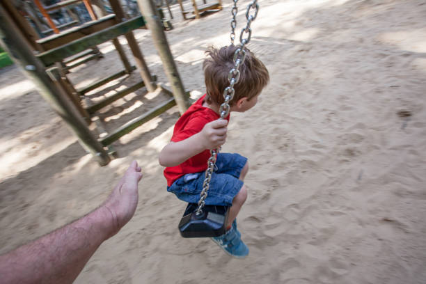 Little boy aged 7 is playing in pine forest playground on tuscanian coast near Cecina. Italy, Tuscany. Sunny summer evening.