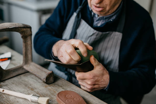 istock Old shoemaker working at the shop 673450728