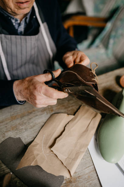 istock Shoemaker shears the edges of the skin 673457776