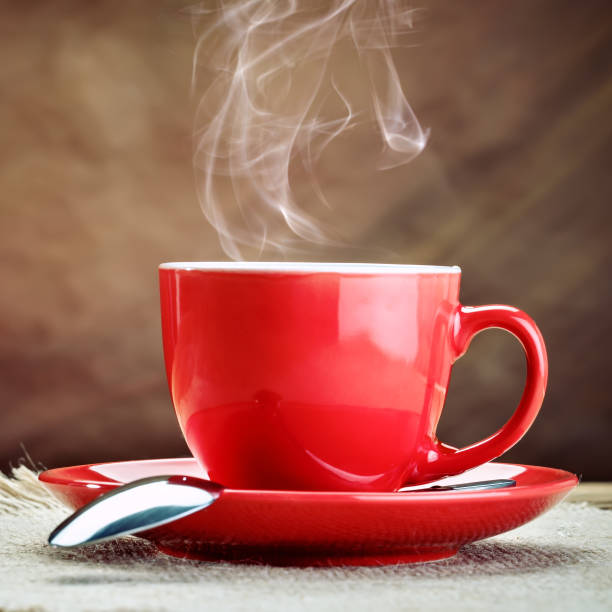 istock Red ceramic cup with hot coffee on wooden boards 673464270